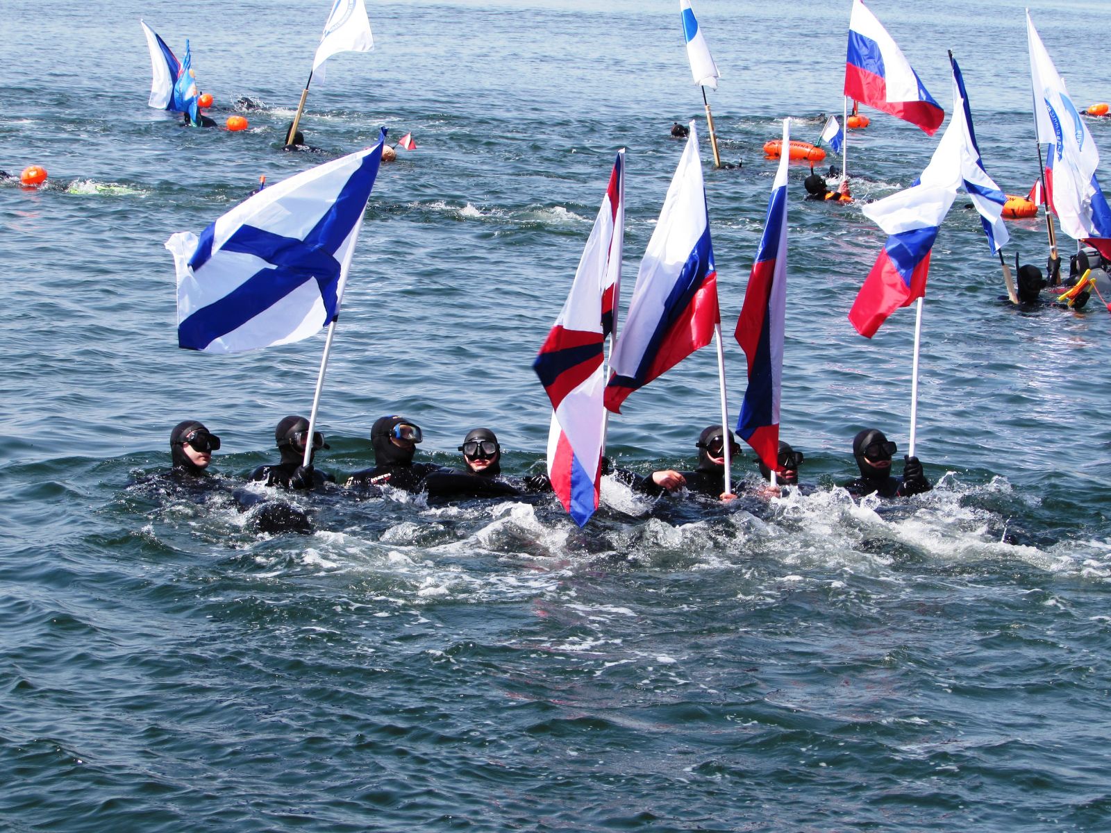 Самые подготовленные пловцы заручились флагами России, чтобы с берега заплыв смотрелся красивее. Фото: Любовь ХМЕЛЕВСКАЯ